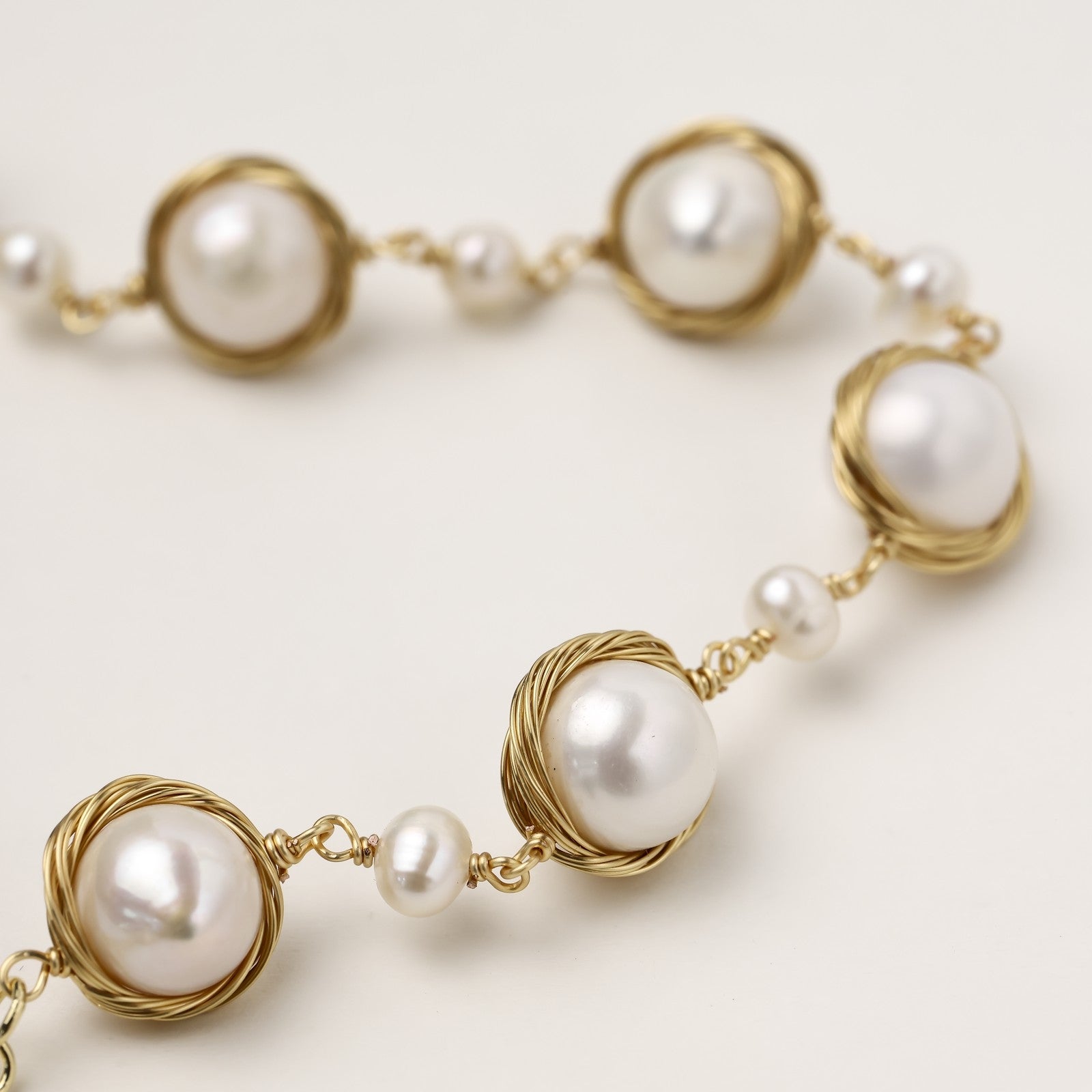 14K gold plated bracelet featuring wire-wrapped freshwater pearls in nest-like settings with adjustable chain closure