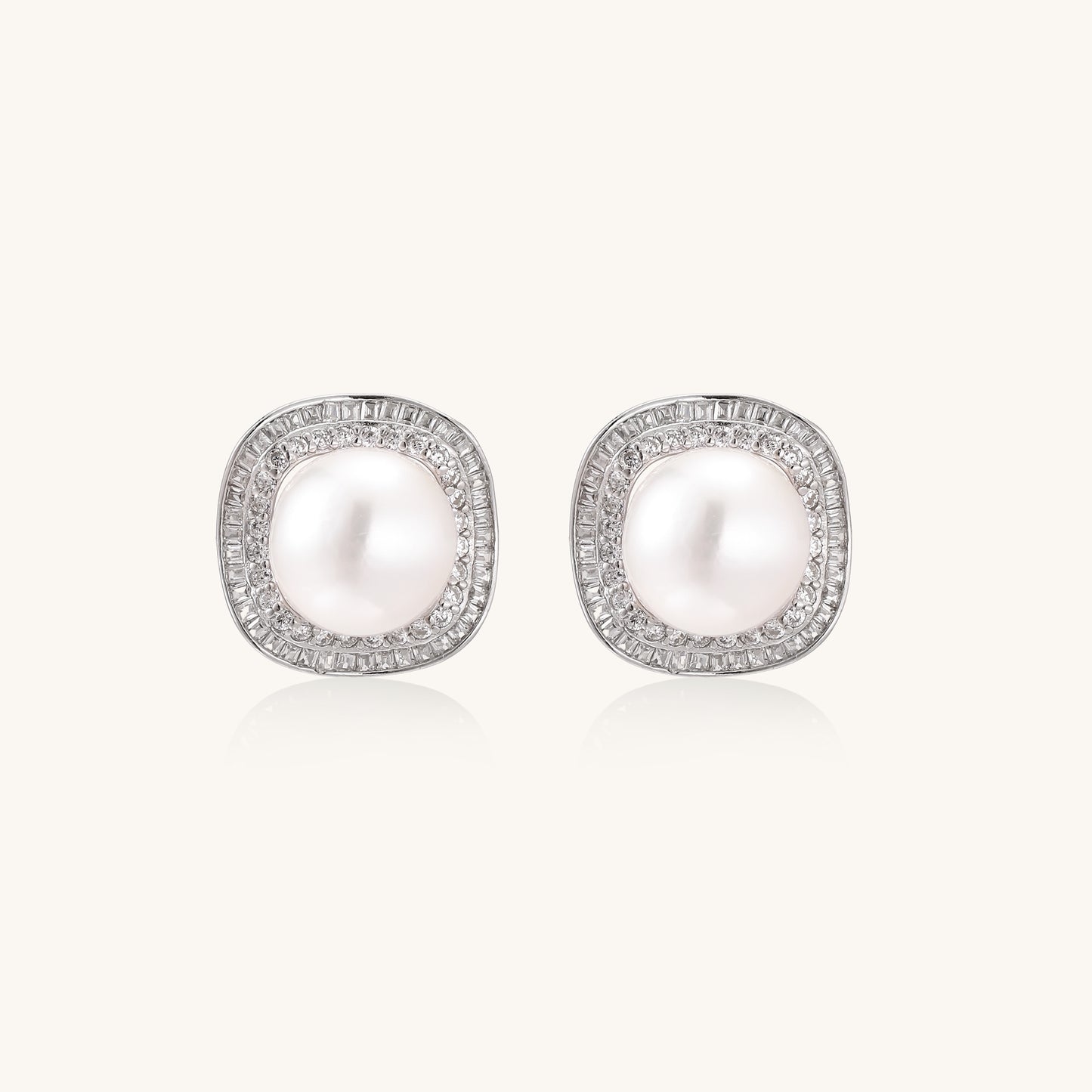 Sterling silver stud earrings with round freshwater pearls surrounded by sparkling crystal halos on white background.
