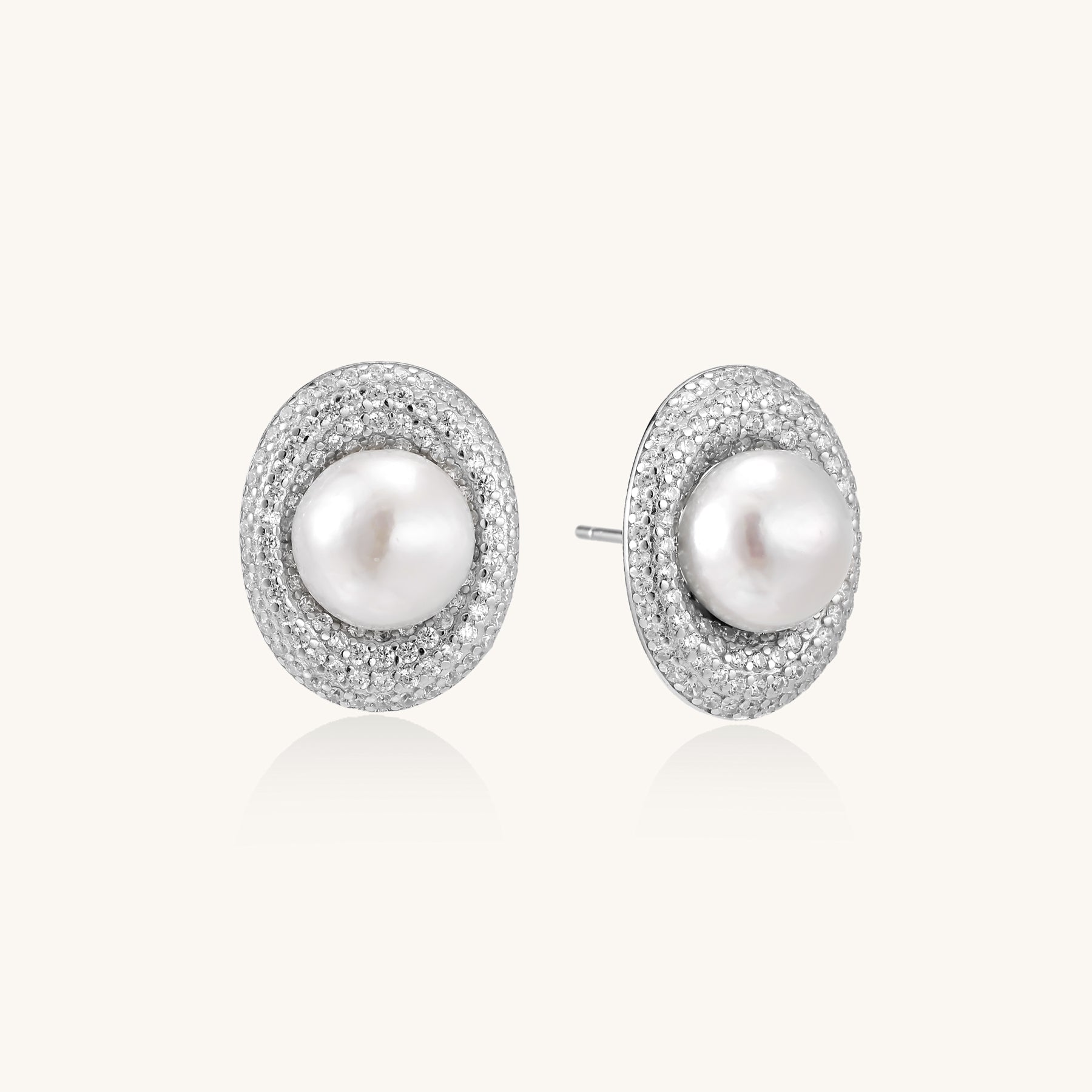 Sterling silver stud earrings with freshwater pearls surrounded by sparkling pavé crystals on white background.