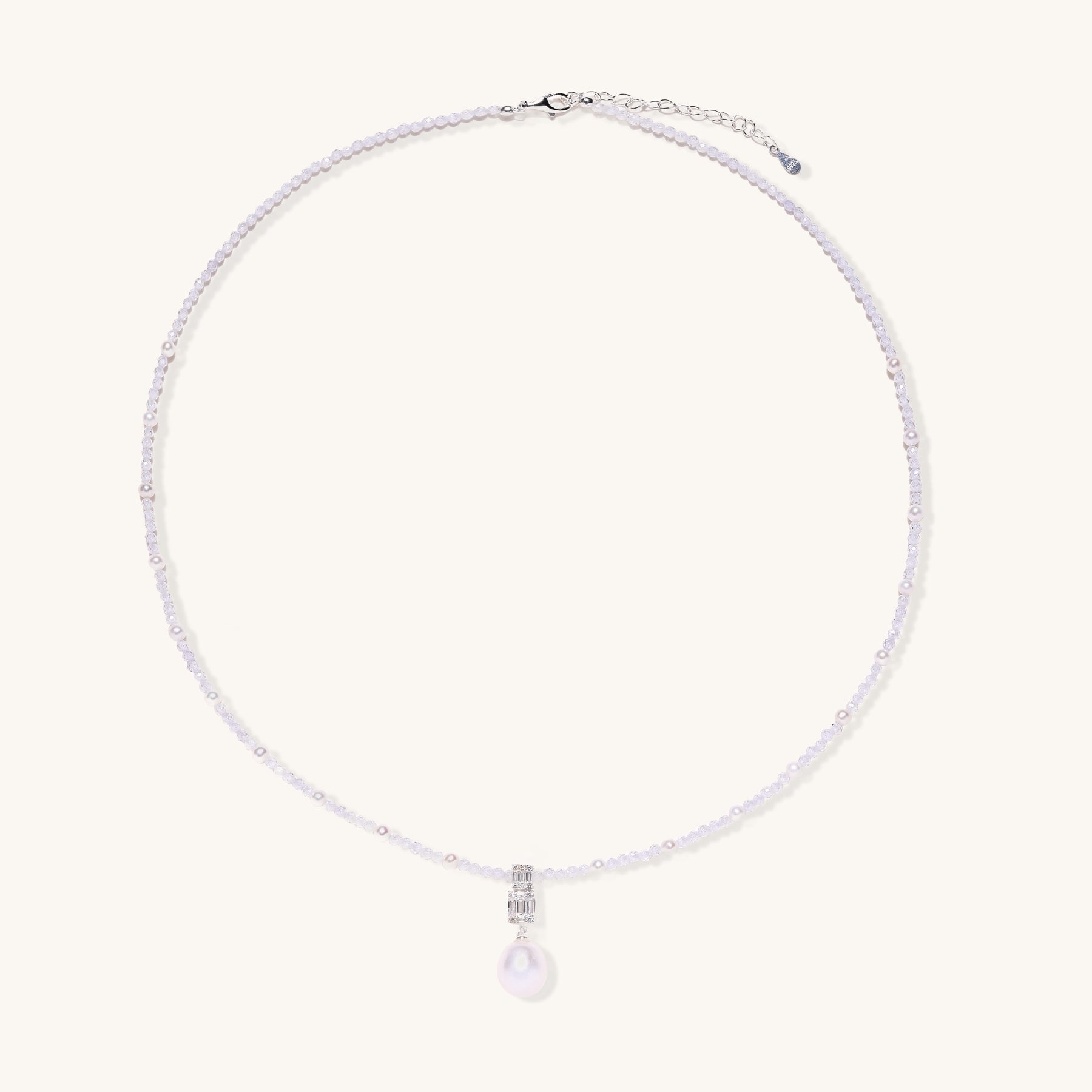 Delicate beaded necklace with lavender crystals, white pearls, and crystal pendant with pearl drop on white background.