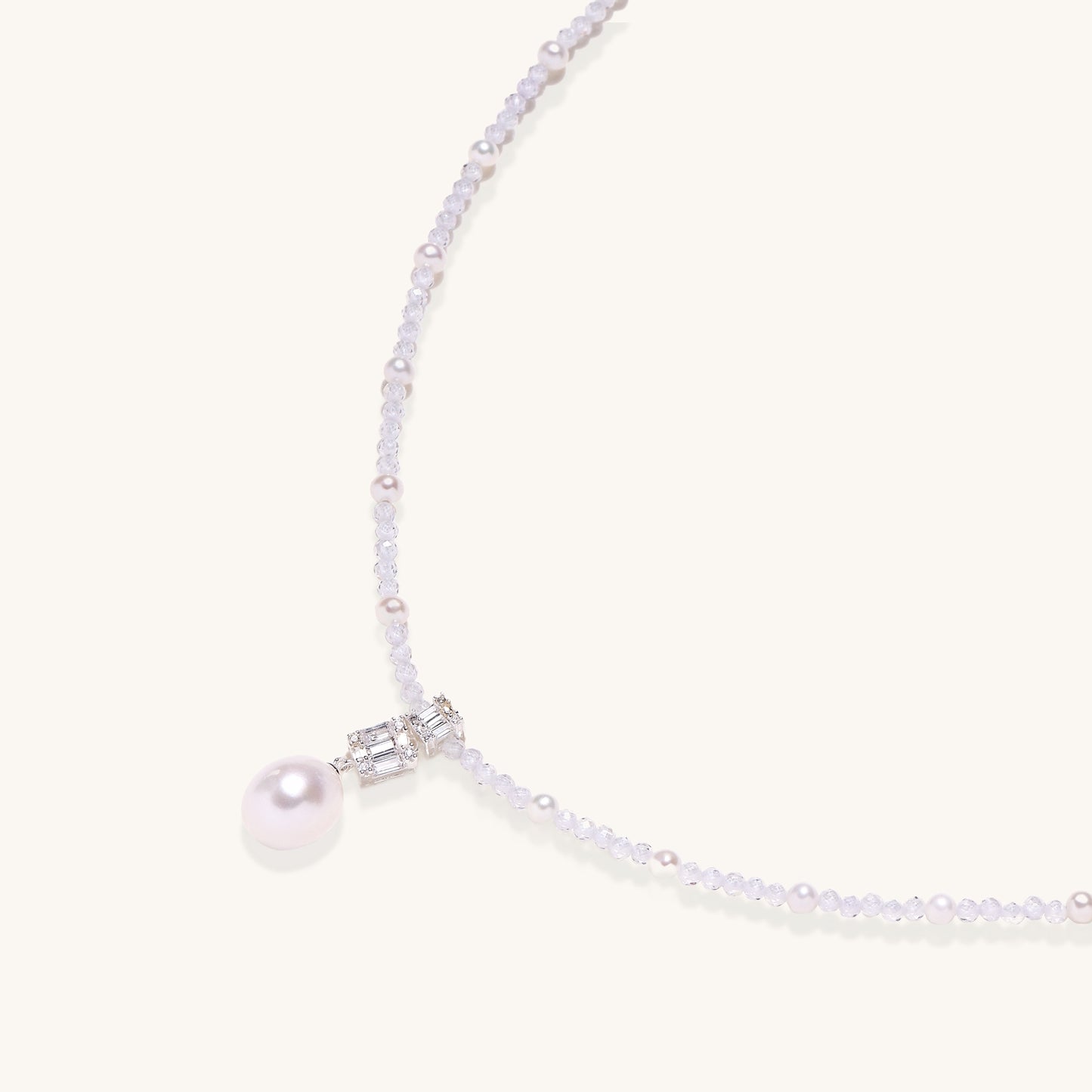 Delicate beaded necklace with lavender crystals, white pearls, and crystal pendant with pearl drop on white background.