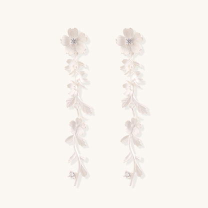 Pair of sterling silver dangle earrings with intricate leaf vine patterns and crystal accents on white background.