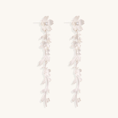 Pair of sterling silver dangle earrings with intricate leaf vine patterns and crystal accents on white background.