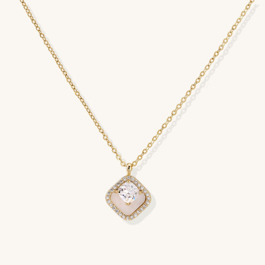 Gold-plated necklace with cushion-shaped pendant featuring a freshwater pearl surrounded by crystal halo on white background.