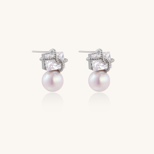 Gold-plated stud earrings with square crystal tops wrapped in twisted wire and freshwater pearl drops on white background
