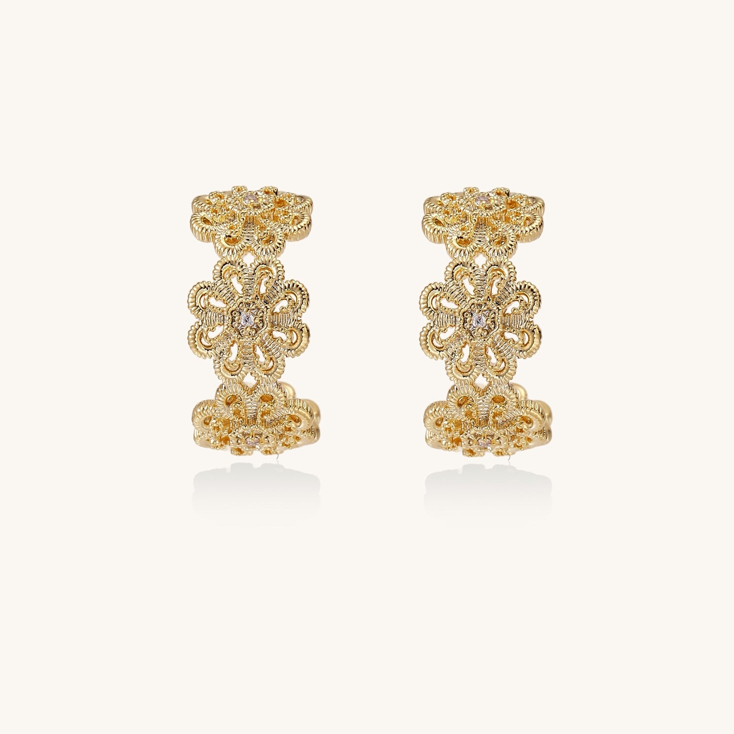 Ornate gold-plated brass hoop earrings featuring delicate floral filigree patterns and intricate rosette details.
