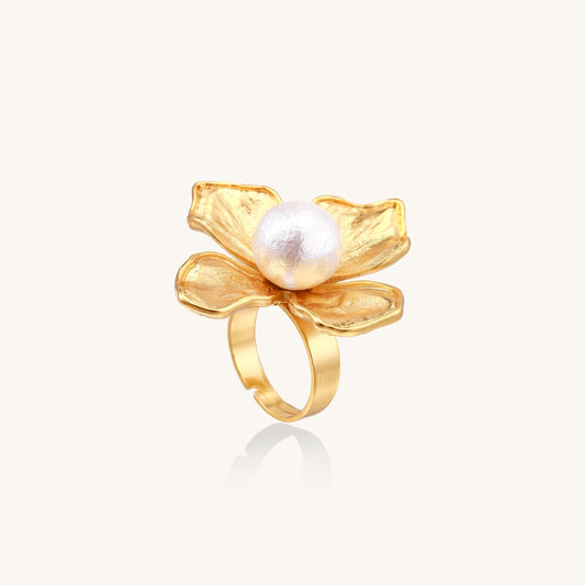 Gold-plated brass ring with dimensional 5-petal flower design and white cotton pearl center on neutral background.