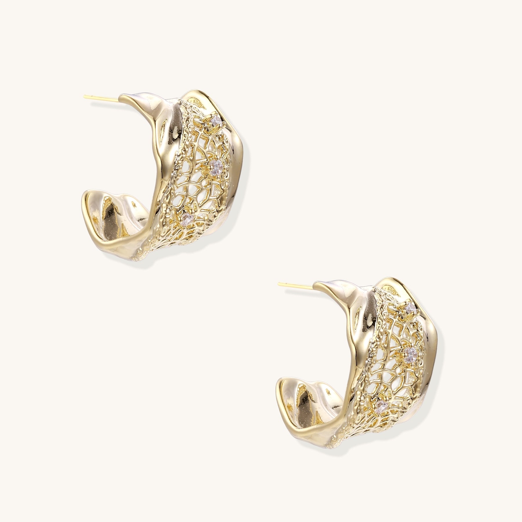 Close-up of gold-plated brass hoop earrings with geometric lattice pattern and sparkling zirconia stones