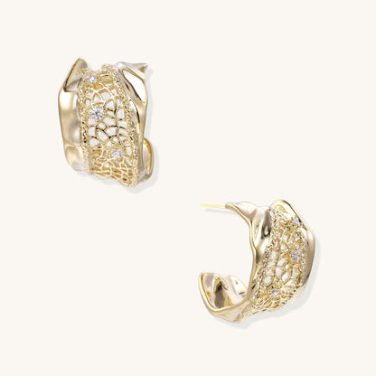 Close-up of gold-plated brass hoop earrings with geometric lattice pattern and sparkling zirconia stones