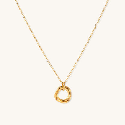 Close-up of a gold-plated stainless steel necklace with interlocking twisted ring pendant on white background