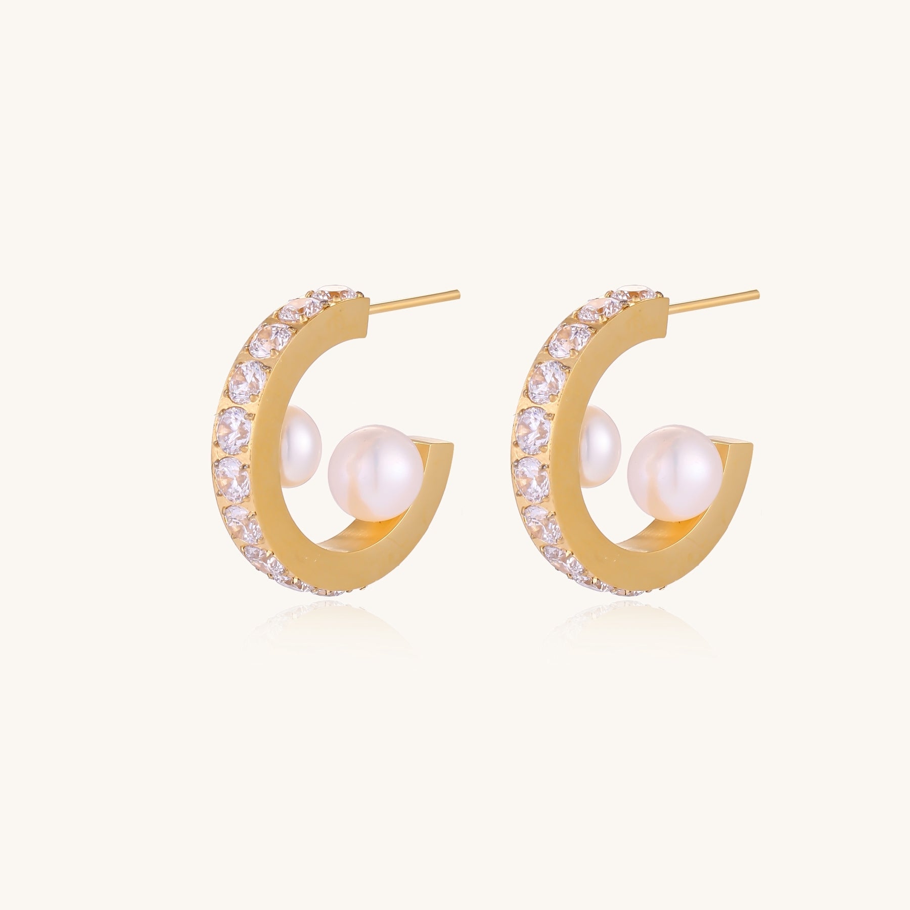 Gold-plated hoop earrings with crystal pavé and floating freshwater pearls inside the circular design.