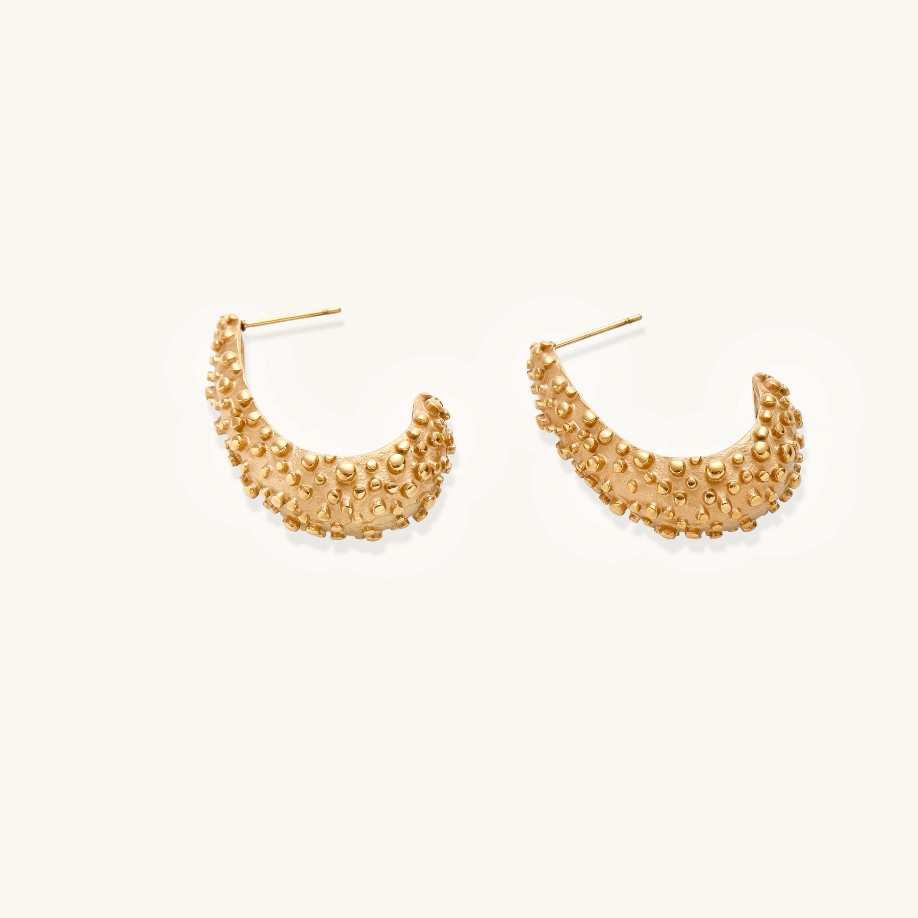 Pair of gold-plated hoop earrings with raised dotted texture surface shown from multiple angles on white background.
