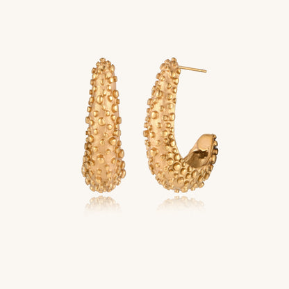 Pair of gold-plated hoop earrings with raised dotted texture surface shown from multiple angles on white background.