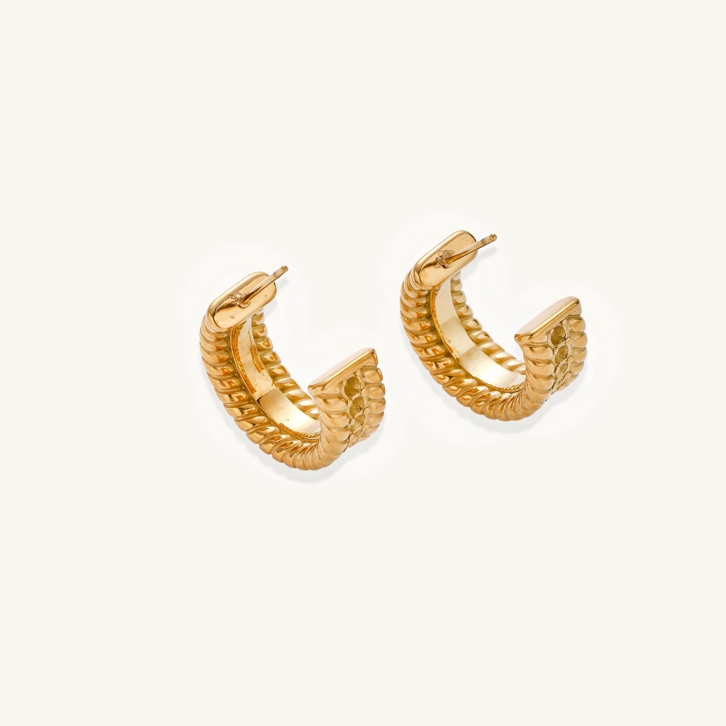 Close-up of 14K gold plated textured hoop earrings with rope pattern against cream background showing convertible design