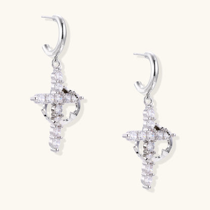 Ornate cross dangle earrings with zirconia stones and gold-plated brass construction on white background.