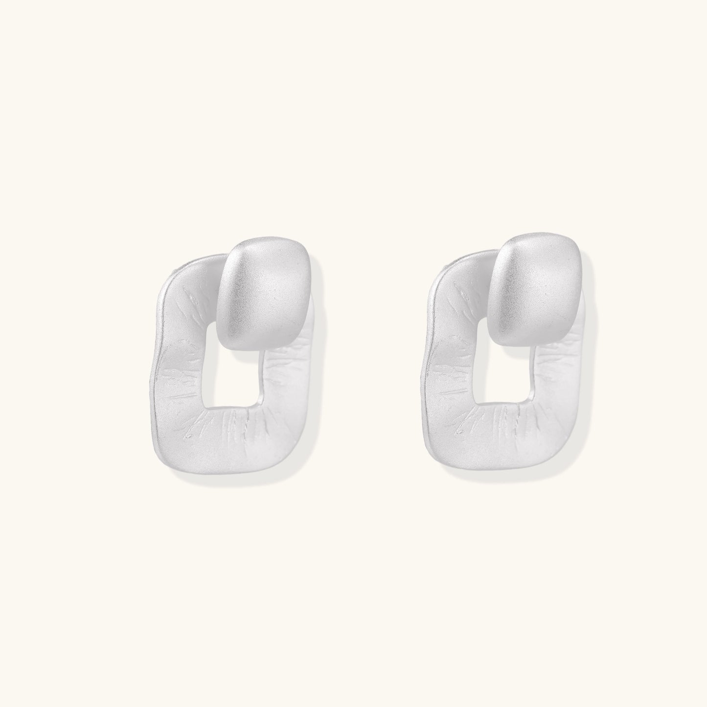 Geometric sterling silver square stud earrings with brushed texture and central square cutouts on white background.