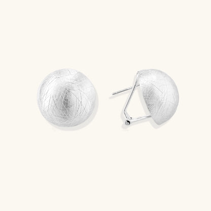 Brushed sterling silver dome-shaped stud earrings with textured surface and secure lever-back closure on white background.
