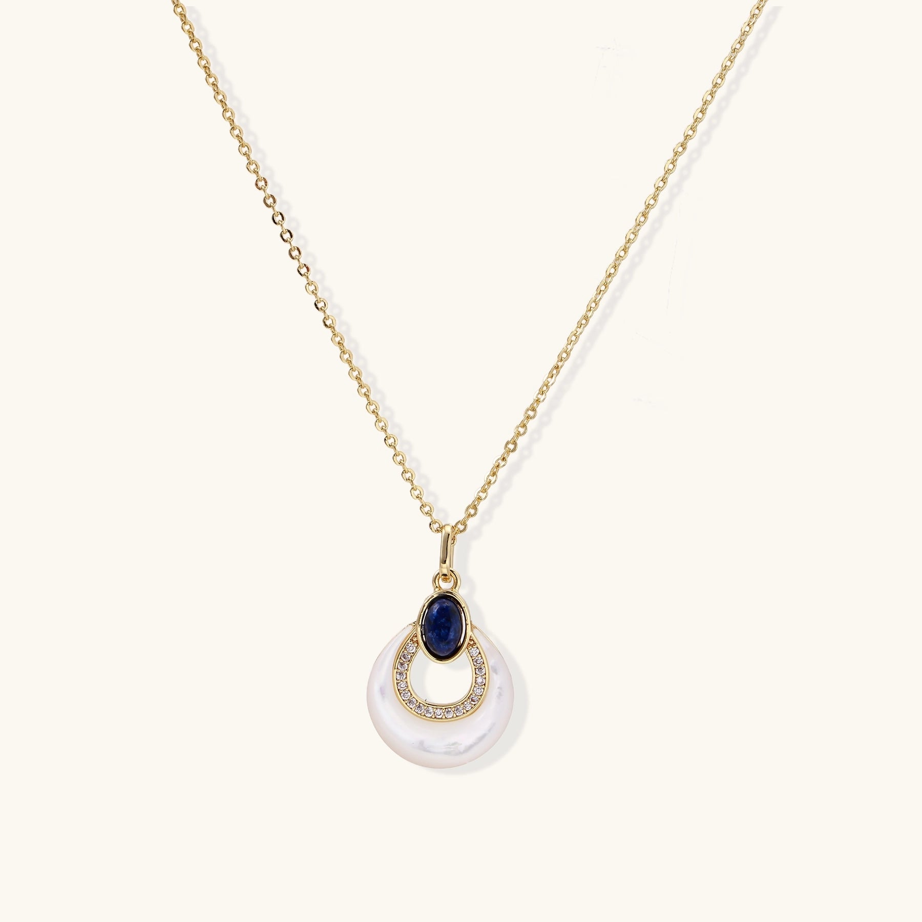 Layered pendant necklace with deep blue lapis lazuli stone, crystals, and white mother of pearl on 18k gold plated chain