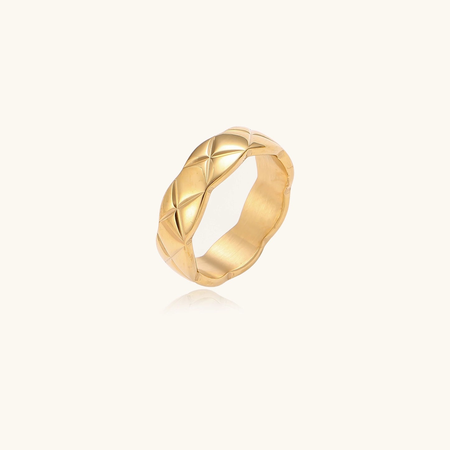 18K gold plated stainless steel ring with geometric twisted band design on neutral background