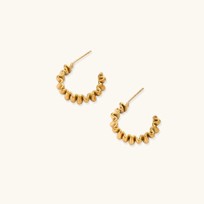Gold-plated stainless steel earrings with twisted rope texture in various hoop sizes on neutral background.