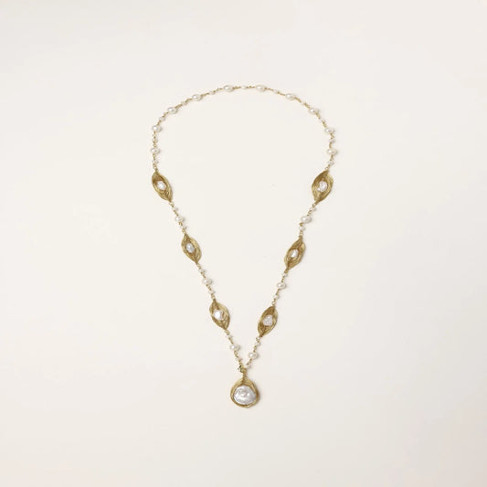 14K gold-plated necklace with eye-shaped stations and baroque pearl pendant on cream background