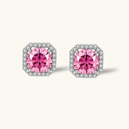 Pink moissanite studs in octagonal sterling silver halo settings with sparkling accent stones on cream background.
