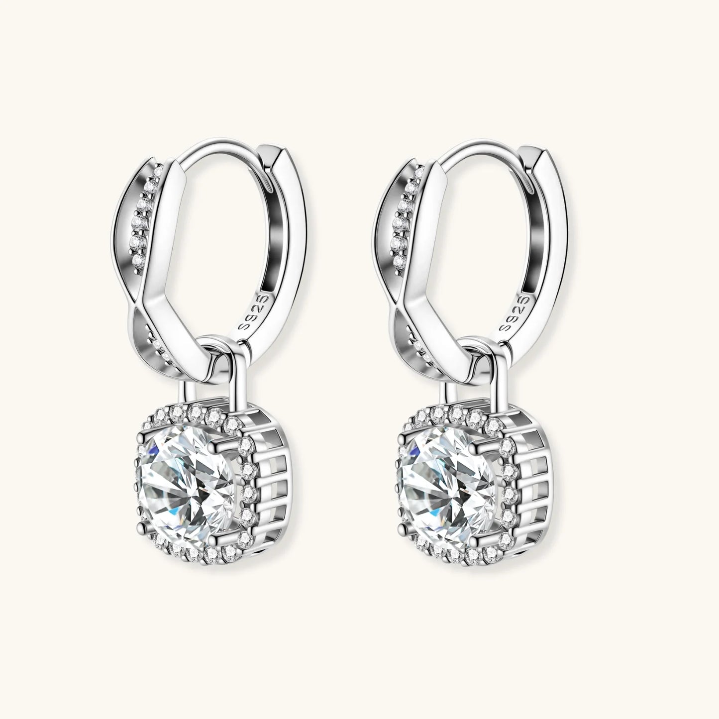 Sterling silver twisted hoop earrings with round moissanite stones in halo settings against neutral background.