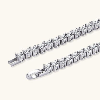 Sterling silver tennis bracelet with continuous row of brilliant moissanite stones and secure clasp closure on cream background.