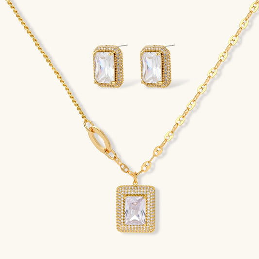 Gold-plated jewelry set with rectangular cubic zirconia stones in pave halo settings on cream background