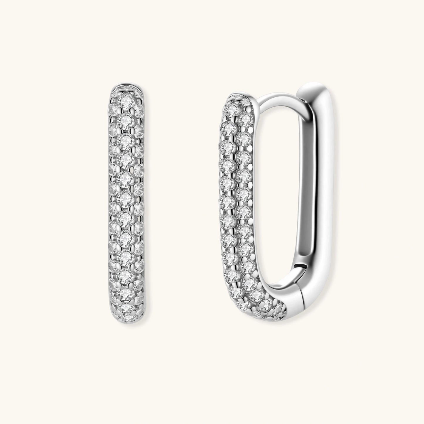 Close-up of platinum-plated sterling silver huggie hoops with pavé crystal setting on white background.