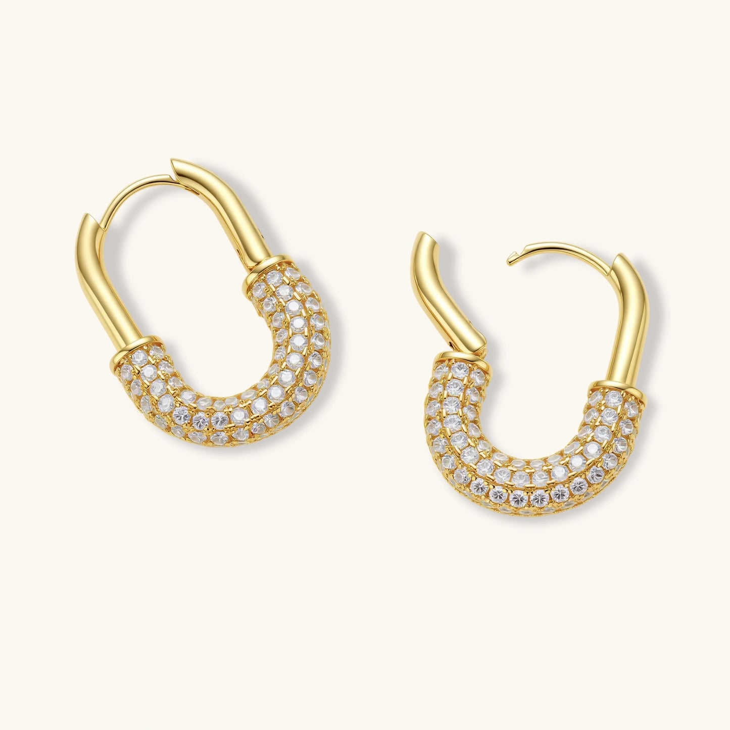 Gold-plated huggie hoop earrings with pavé zirconia stones covering the bottom curve, shown in open and closed positions.