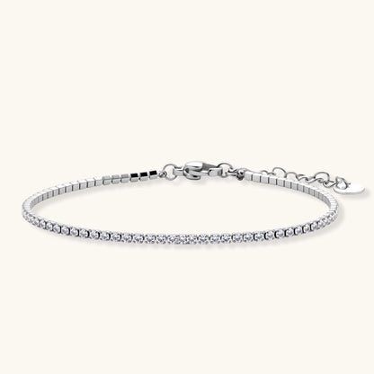 Silver stainless steel tennis bracelet with a single row of clear round zircon stones, lobster clasp, and adjustable extender chain.